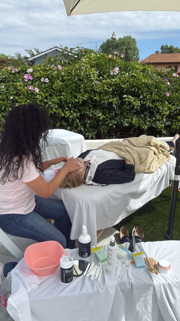 A spa professional providing a treatment to a guest.