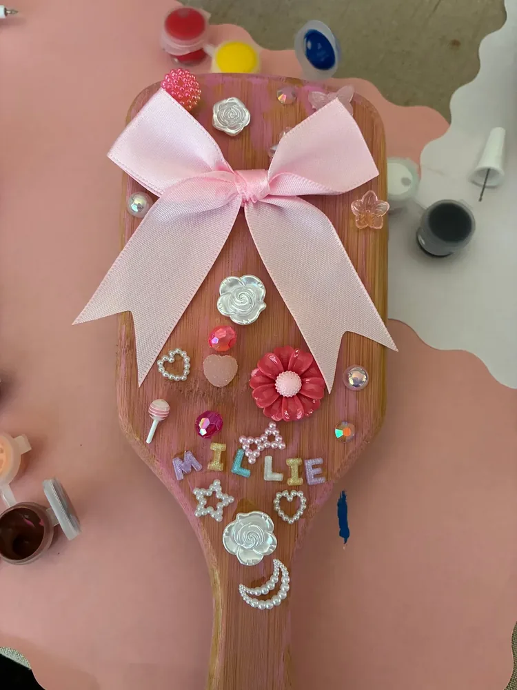 A decorated apron and colorful embellishments arranged on a craft table.